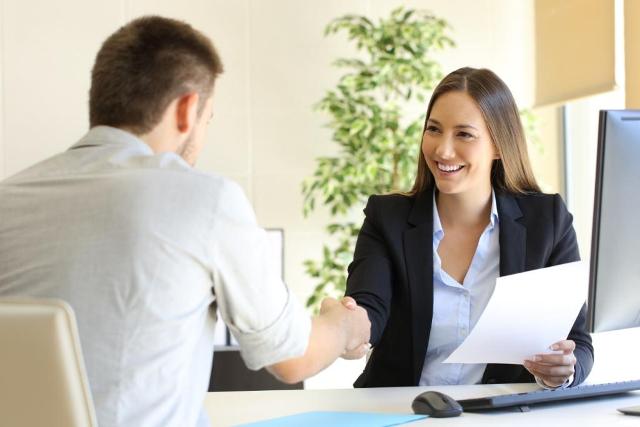 Smiling hiring manager shaking a job candidate's hand
