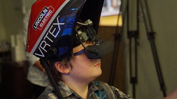 Image shows a Bridgemania 2016 participant with virtual welding mask who is about to try welding using the virtual welder.