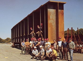 Williamsport Plant 3 co-workers stand in front of a large girder in 1985, the year the plant was acquired by High Steel Structures LLC.