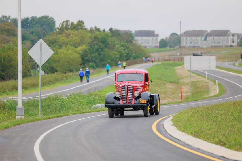 High Welding truck driving on new road with runners and bicyclists in the background